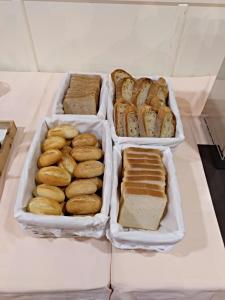 three trays of bread and pastries on a table at FC Infantas de León in León