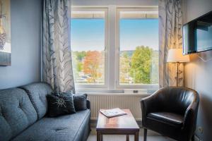 a living room with a couch and a chair and a window at Hotel Sollefteå in Sollefteå