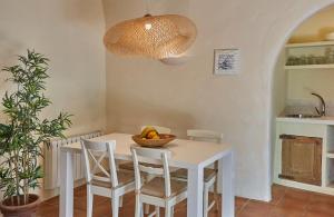 una mesa con sillas y un bol de fruta en ella en Casa Marqués at Masia Nur Sitges, Adults only, en Canyelles