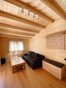 a living room with a black couch and a table at Camping Piccolo Paradiso in Avegno