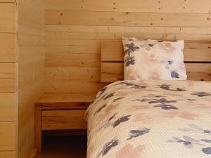 a bedroom with a bed and a wooden wall at Camping Piccolo Paradiso in Avegno