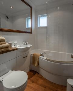 Un baño con bañera, inodoro y lavabo. en Cranborne House, en Poole