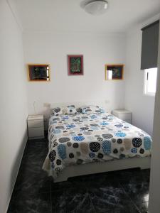 Un dormitorio con una cama con un edredón azul y blanco. en Sun and Sea House 3 Rooms & Wifi, en Arinaga