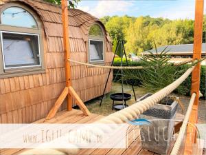 a tree house with a hammock in front of it at Iglu Camp Königsberg in Wolfstein