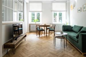 un soggiorno con divano verde e tavolo di Warsaw Heritage Apartment a Varsavia