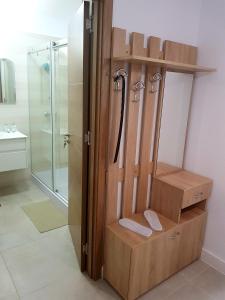 La salle de bains est pourvue d'une douche et d'un placard en bois. dans l'établissement Cosy suite apartment, Onix Blue Residence, Mamaia Nord, à Mamaia Nord – Năvodari
