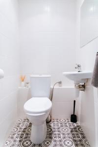 biała łazienka z toaletą i umywalką w obiekcie Comfortable & Spacious Lodz City Center Apartment w Łodzi