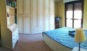 een slaapkamer met een bed met blauwe lakens en een lamp bij Trilocale con box cantina a Robilante in Robilante