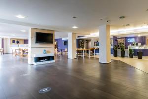 a lobby with a flat screen tv and tables and chairs at Holiday Inn Express Norwich, an IHG Hotel in Norwich