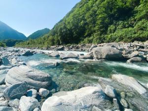 a river with rocks in the middle of a mountain at Camping Piccolo Paradiso in Avegno