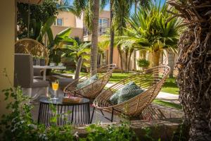 a patio with chairs and a table and palm trees at Danaides in Malia