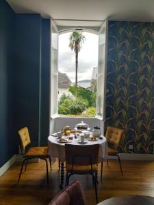 a dining room with a table and a large window at Gaïnaa in Arudy