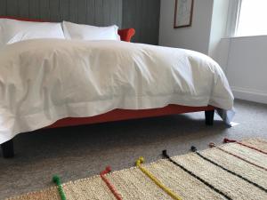 ein Schlafzimmer mit einem Bett mit einer weißen Bettdecke und einem Bett mit in der Unterkunft The Loft, Flat 3 in Bath
