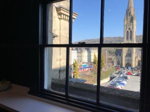 a window with a view of a street and a church at The Loft, Flat 3 in Bath