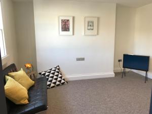 a living room with a couch and a tv at The Loft, Flat 3 in Bath