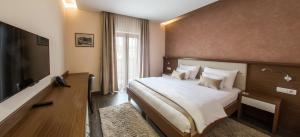 Cette chambre comprend un grand lit et une télévision. dans l'établissement Hotel Mostar, à Mostar