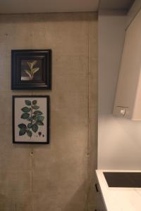 two framed pictures on a wall in a kitchen at Home Again Apartments Kirkegata in Stavanger