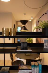 a shelf with books and a laptop on it at Home Again Apartments Kirkegata in Stavanger