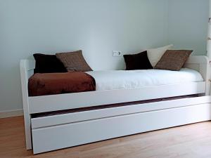 a white bed with pillows on it in a room at Apartamento OD in Piedras Blancas