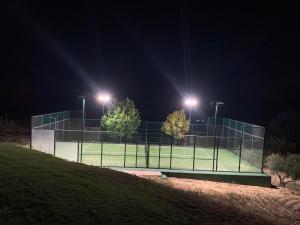 una pista de tenis por la noche con luces encendidas en Casa Herreros - Alojamiento Rural con Pista de Padel, en Rada de Haro