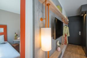 a room with a bed and a tv and a lamp at ibis budget Nice Californie Lenval in Nice