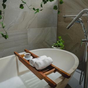 a bathroom with a bath tub with a towel on a tray at Villa Aquin in Solo