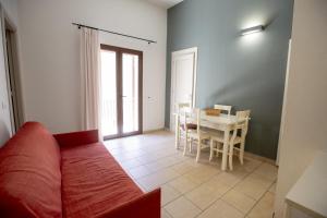 a living room with a red couch and a table at Le Plejadi in Castellammare del Golfo