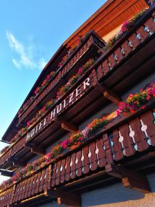 a building with flower boxes on the roof at Hotel Holzer in Sesto