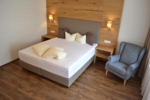 a bedroom with a bed and a blue chair at Hotel Neue Post in Sölden