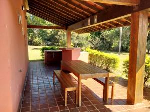 a wooden bench sitting on a patio under a pergola at Chácara San Diego - Brotas in Brotas