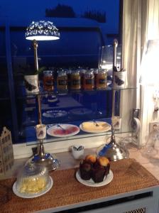 a counter with plates of pastries and a table of food at B&B La demeure du Papillon in Mouscron