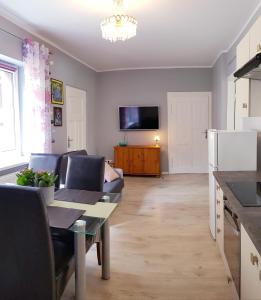 eine Küche und ein Wohnzimmer mit einem Tisch und einem Sofa in der Unterkunft Niebieskie Migdały in Karpacz