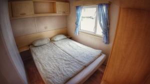 uma pequena cama num pequeno quarto com uma janela em Triocamp Praha em Praga