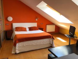 Un dormitorio con una cama con una pared naranja. en Apartamentos Albariño, en Vegadeo
