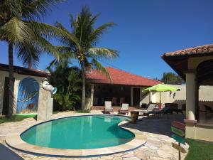a swimming pool in the yard of a house at Pousada da Luz in Aquiraz