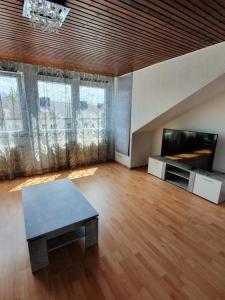 een grote woonkamer met een tafel en een televisie bij LA CASITA in Düren - Eifel