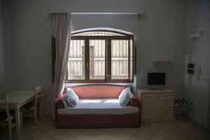 a bedroom with a bed and a window and a desk at Le Plejadi in Castellammare del Golfo