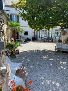 a park with benches and a tree and a building at La maison du grand rocher in Ploubazlanec