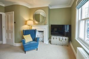 uma sala de estar com uma cadeira azul e uma televisão em Host & Stay - Henderson House em Whitby