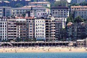 a view of a beach with buildings and people on it at Hotel Niza in Donostia-San Sebastián