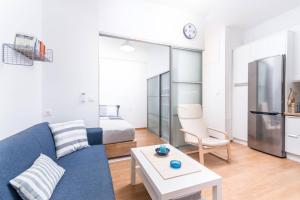 ein Wohnzimmer mit einem blauen Sofa und einem Bett in der Unterkunft Garconniere Sonja in Pitsidia
