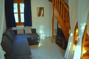 a living room with a couch and a staircase at Kalokairi Cottage in Skopelos Town