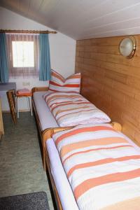 a bed in a small room with a striped comforter at Ferienwohnung Bickel in Sankt Anton im Montafon