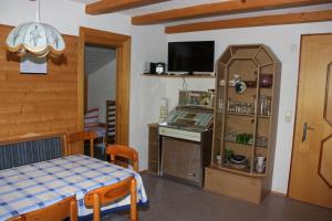 a room with a kitchen and a table and a table and a tv at Ferienwohnung Bickel in Sankt Anton im Montafon
