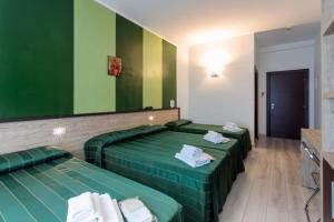 2 letti in una camera con pareti verdi e gialle di Hotel Bellavista a Porto San Giorgio