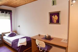 a bedroom with a bed and a desk and a picture at Apartman Jadranka in Zaprešić