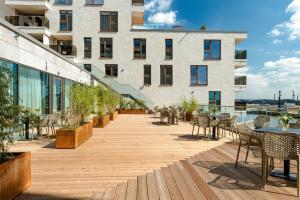 an outdoor patio with tables and chairs and a building at JUFA Hotel Hamburg HafenCity in Hamburg