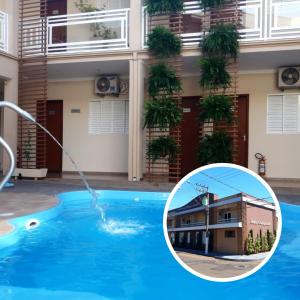 a pool water fountain in front of a building at Casagrande Olímpia Hotel in Olímpia