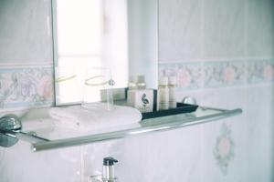 a bathroom with a glass shelf above a sink at The Old Bakery in Kenilworth +62 photos