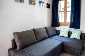 a couch in a living room with a window at Kalokairi Cottage in Skopelos Town